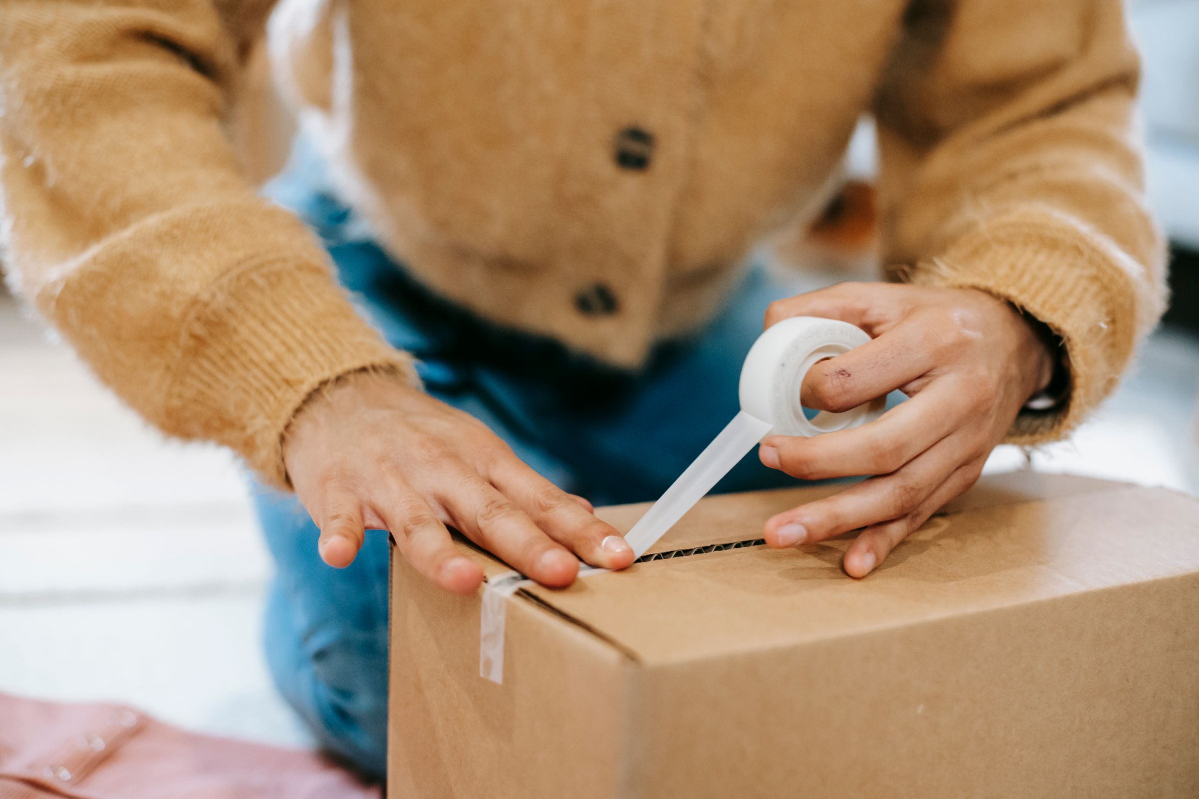 Hands assembling and taping product cartons on a work table